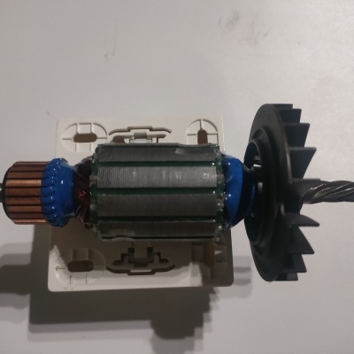 Rotor de motor elétrico com bobinagem e ventoinha numa superfície branca