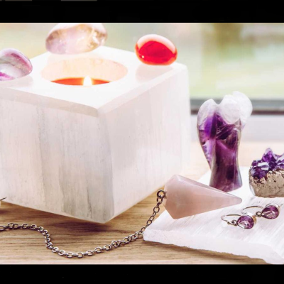 Vela quadrada branca em suporte de pedra com pedras coloridas e joias esculpidas