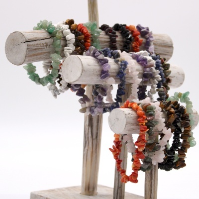 Pulseiras de pedras naturais coloridas em suporte de madeira rústico