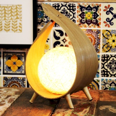 Candeeiro de mesa de madeira com luz esférica sobre mesa rústica e azulejos coloridos