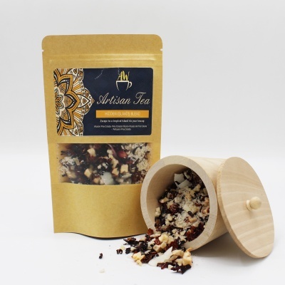 Pacote castanho de chá artesanal junto a recipiente de madeira com chá solto