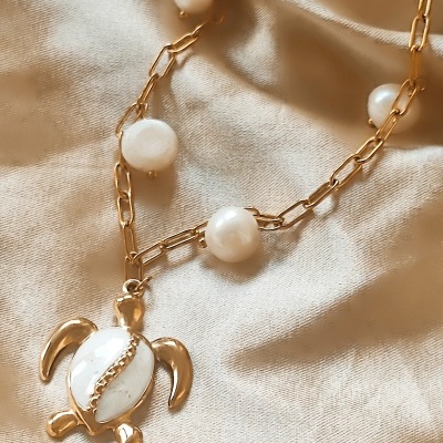 Colar dourado com pérolas e pendente de tartaruga