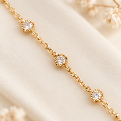 Pulseira dourada com pedras redondas brilhantes sobre fundo creme