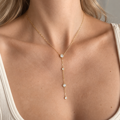 Colar pendente dourado com pedras claras em pescoço feminino