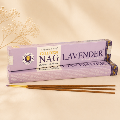 Pacotes de incenso Golden Nag Lavender e varetas de incenso sobre superfície bege.