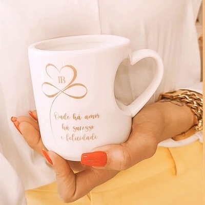 Caneca branca com pega de coração e texto dourado