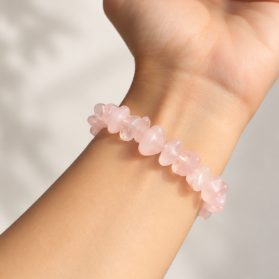 Pulseira de contas em pedra rosa translúcida num pulso
