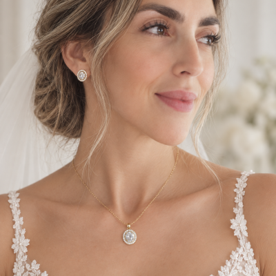 Colar e brincos em ouro com pedras transparentes e cristais, vestido de renda branca