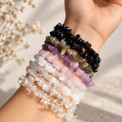 Pulseiras de pedras naturais coloridas num pulso com unhas manicadas cor nude