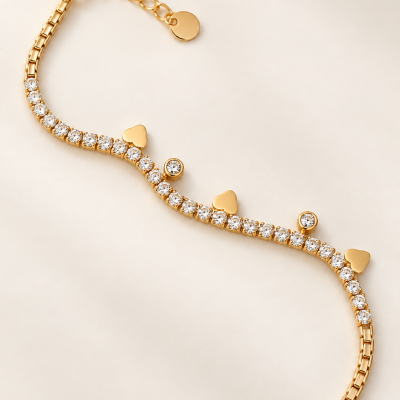 Pulseira dourada com pedras e corações em pano creme