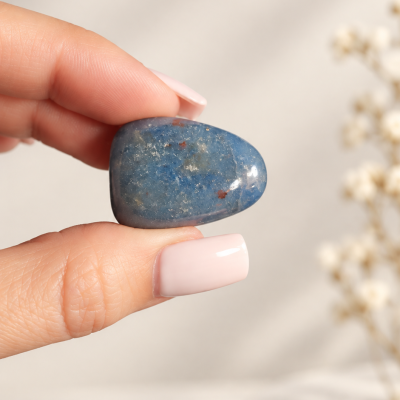 Pedra polida azul segurada entre os dedos