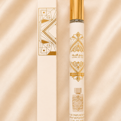Frasco de perfume Badbe Al Oud Honor & Glory com tampa dourada e caixa ao lado sobre tecido bege.