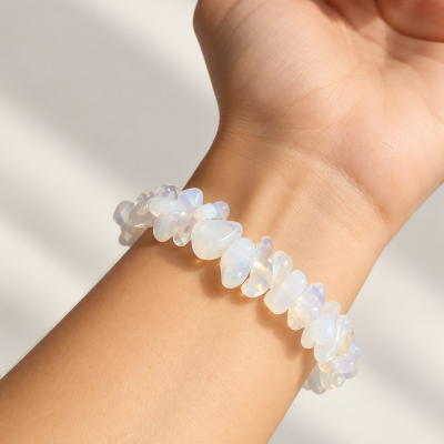 Bracelete elástico com pedras translúcidas brancas e lilases no pulso