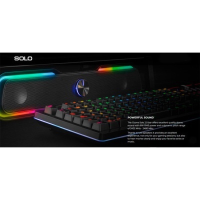 Coluna de som preta com luzes coloridas e teclado mecânico iluminado sobre fundo preto