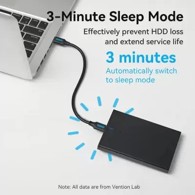 Portátil cinzento com disco externo preto ligado por cabo