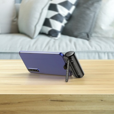 Smartphone azul num suporte preto com tripé na mesa diante de sofá com almofadas