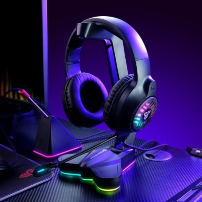 Headset preto com LED colorido numa mesa escura com fundo roxo