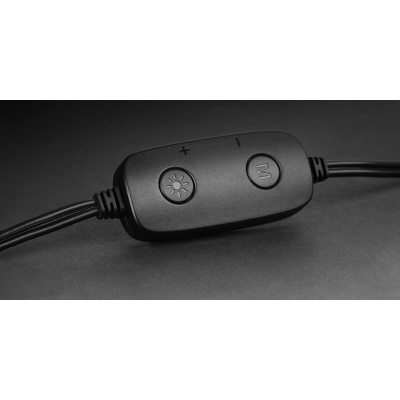 Comando preto com três botões e cabo em fundo cinzento escuro