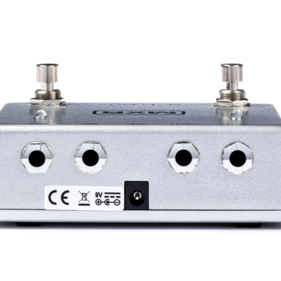 Pedal de efeito para guitarra metálico prateado com quatro jacks e duas chaves