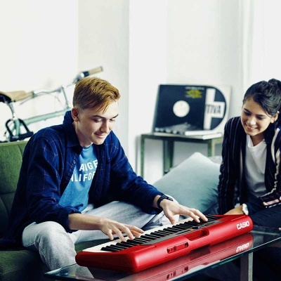 Piano teclado Casio vermelho com adolescentes em ambiente interior