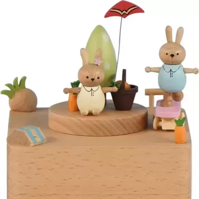 Caixa de música em madeira com coelhos e decoração de cenouras