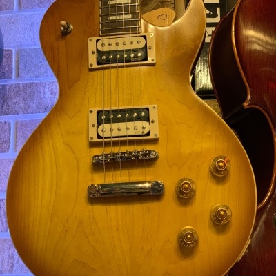 Guitarra elétrica de corpo sólido cor mel com captadores humbucker e botões de controle