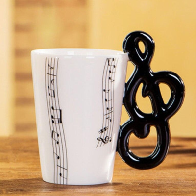 Caneca branca com notas musicais e pega em forma de clave de sol