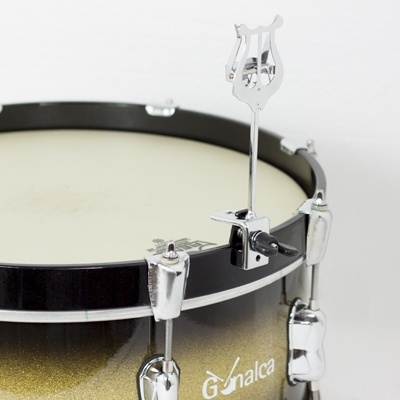 Tambor de bateria dourado com acessórios cromados e suporte em forma de lira