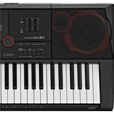 Teclado musical preto com altifalante e botão vermelho