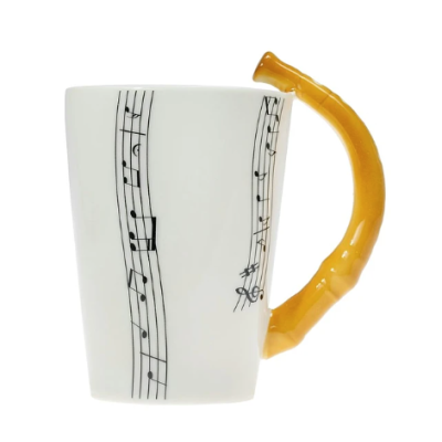 Caneca branca com partituras e pega amarelo-alaranjada em forma de bambu