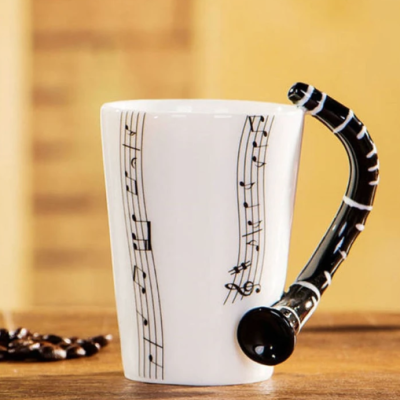 Caneca branca com pauta musical e pega em forma de clarinete preto