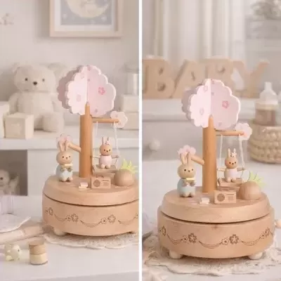 Caixa de música de madeira com figuras de coelhos e árvore cor-de-rosa num quarto de bebé