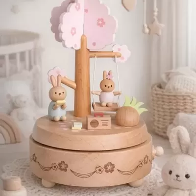 Caixa de música de madeira com dois coelhos e árvore cor de rosa.