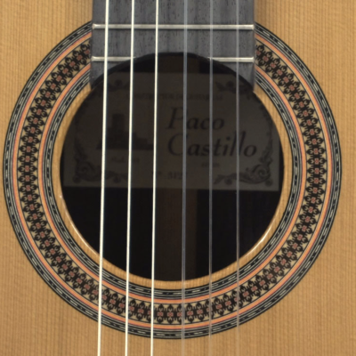 Guitarra clássica com tampa clara e roseta decorativa circular.