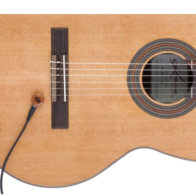 Guitarra clássica em madeira clara com microfone ligado por cabo preto
