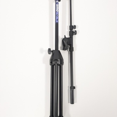 Tripé preto dobrado com etiqueta COSMOWORLD sobre superfície branca