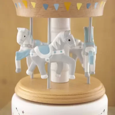 Carrossel musical com cavalos cinza e azul sobre base de madeira clara