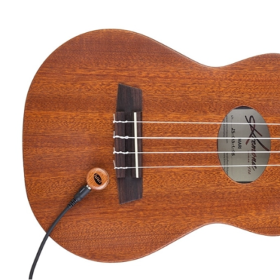 Ukulele em madeira castanha com microfone ligado