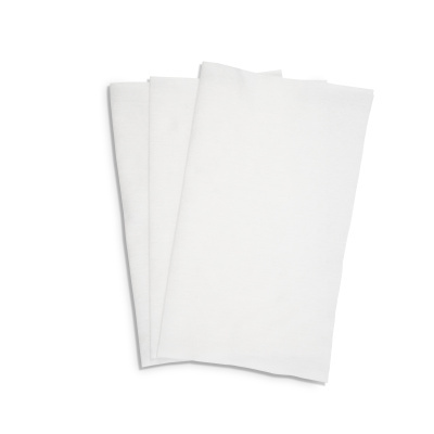Três guardanapos de tecido branco dobrados sobre fundo branco