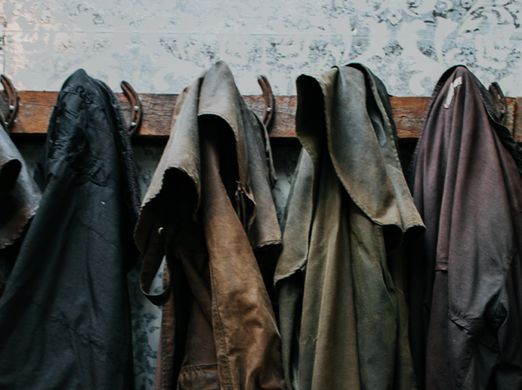 Casacos de couro pendurados em cabide de madeira
