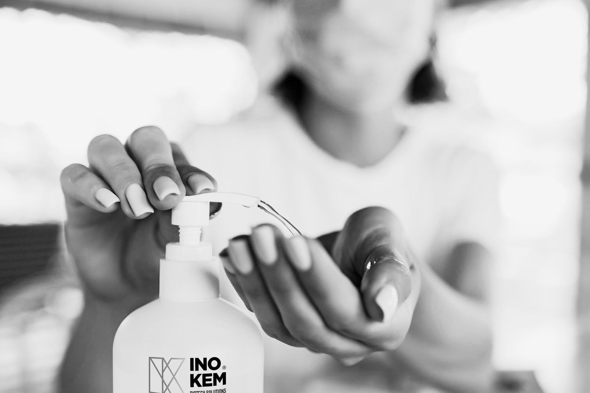 Como se proteger contra a Covid-19? Pessoa a usar desinfetante de mãos INO.KEM preto e branco