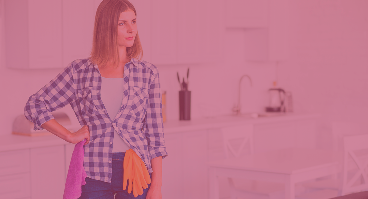 Mulher com camisa xadrez e luvas de limpeza na cozinha