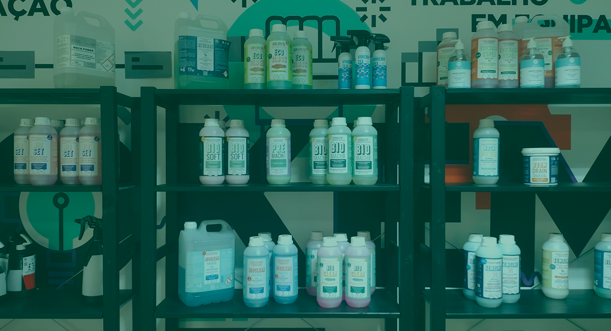 Estantes com frascos plásticos de produtos de limpeza com etiquetas brancas e verdes