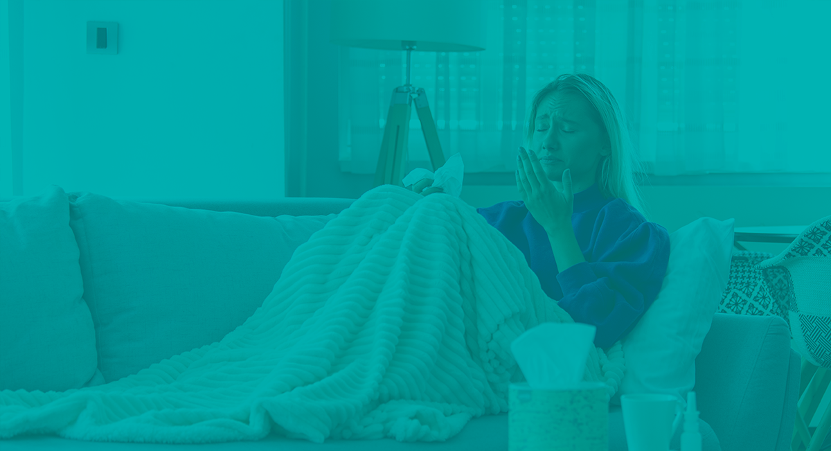 Mulher no sofá com manta branca e lenço