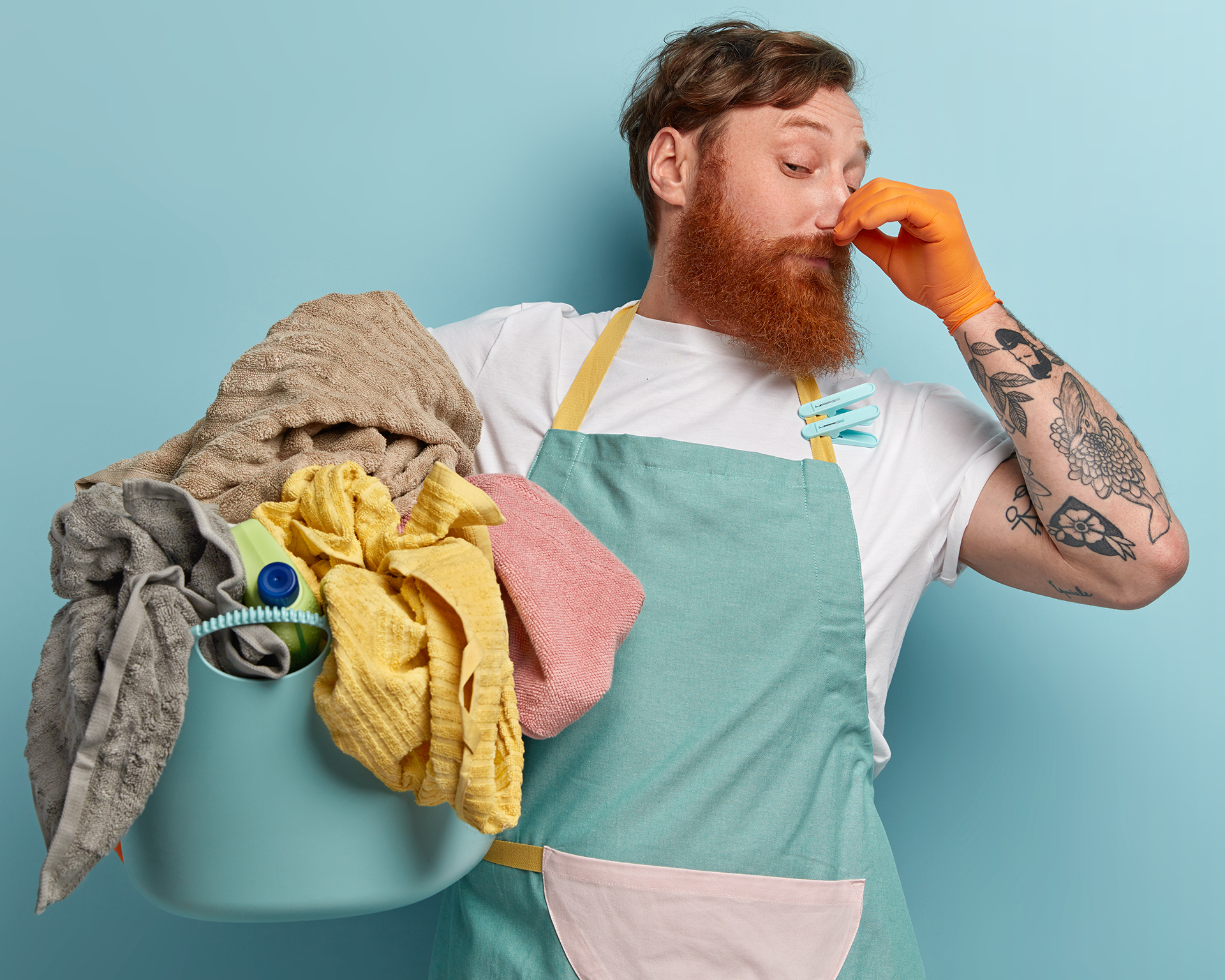 Detergente de Roupa Enzimático 3 em 1 para Nódoas e Odores Difíceis - BIOMACH PRO+PET Homem com avental e luvas segurando toalhas e tapando o nariz