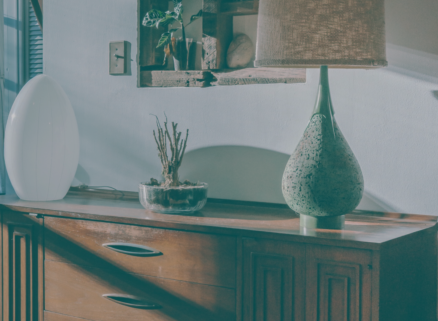 Móvel de madeira com plantas e lâmpadas decorativas em ambiente interior