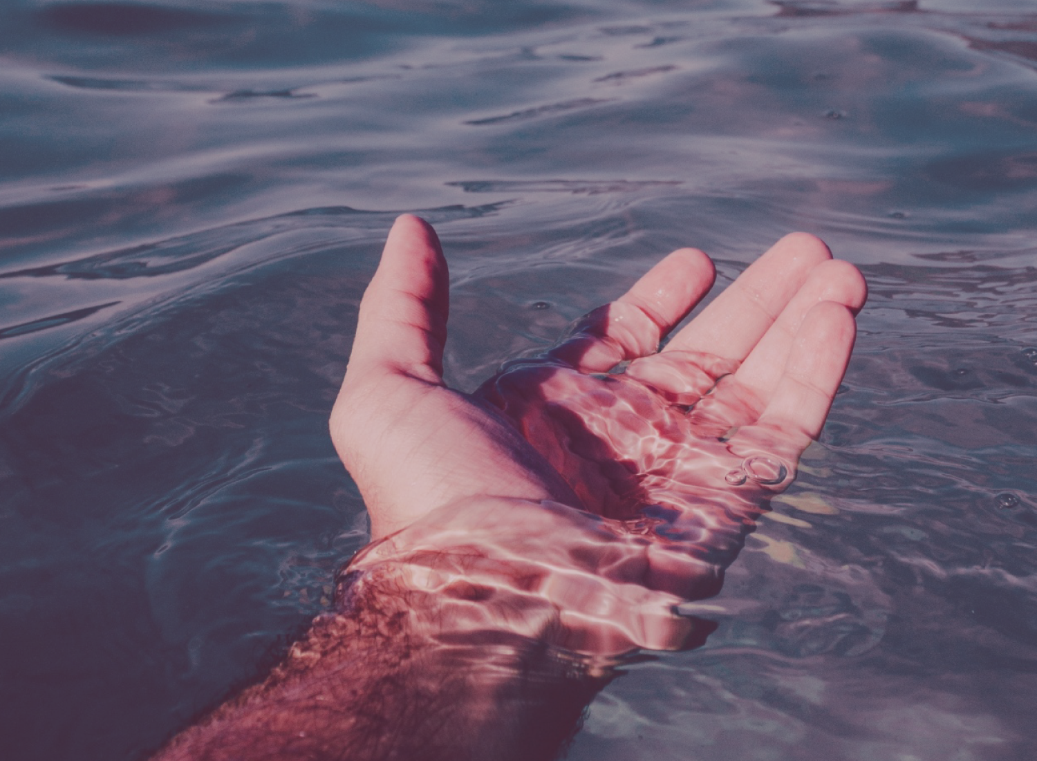 Mão humana parcialmente submersa em água ondulada