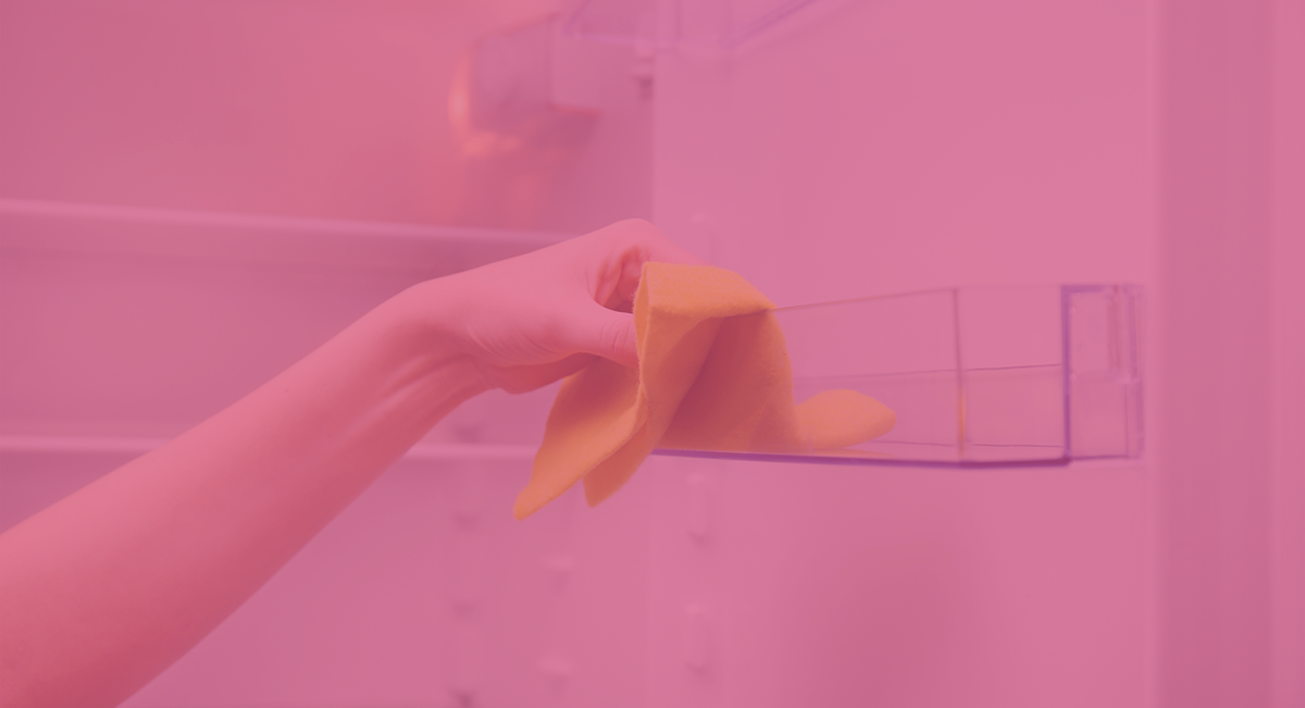 Como limpar o frigorífico corretamente - 5 dicas Mão a limpar prateleira transparente com pano amarelo