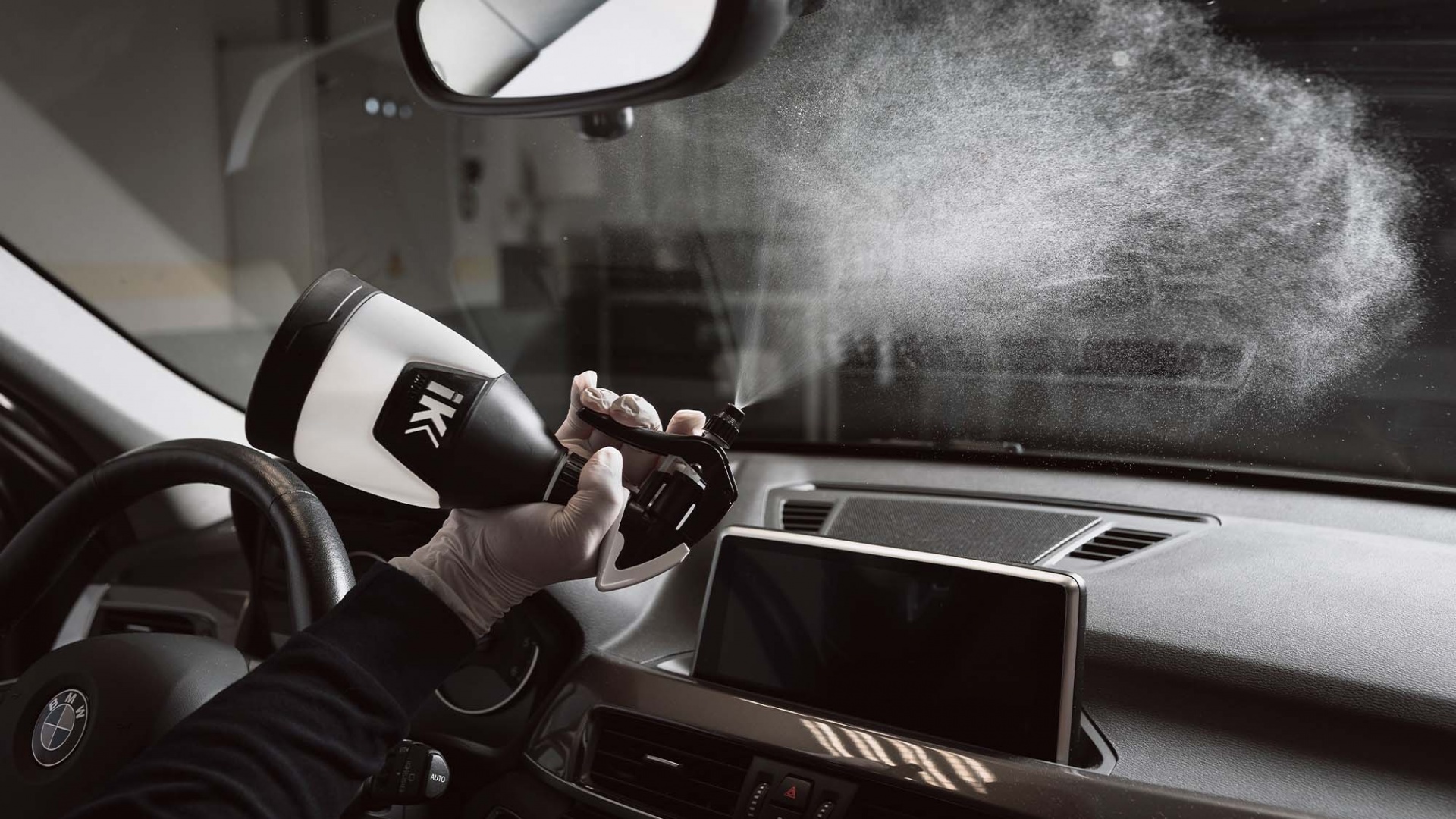 Pulverizador Pul Mini 360°- 500ml Pulverizador spray numa mão dentro do carro, spray visível no ar