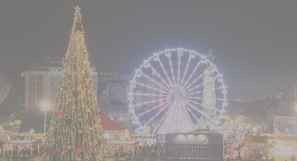 Árvore de Natal iluminada com roda-gigante ao fundo à noite